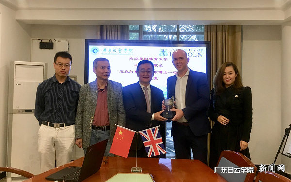 双方互换纪念品(左3:刘根正副校长, 右2:迈克尔·加里摩尔院长).png