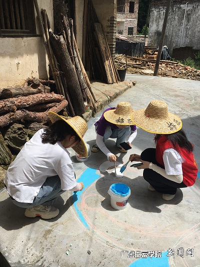 温彩丹所在的志愿团队正在地上进行彩绘.jpg